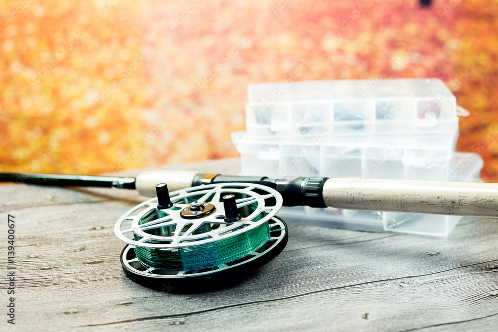 Fototapeta premium fishing spinning rod with reel on the wooden table