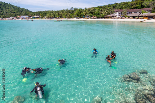 A group of Scuba Diving students have a lesson in shallow crystal clear water of a Tropical Island