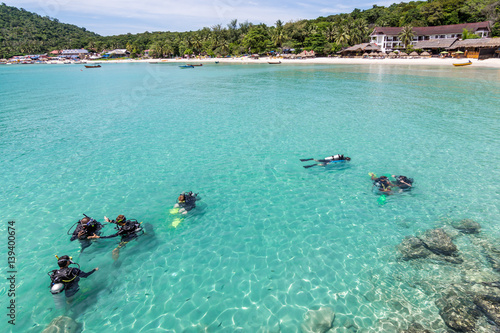 A group of Scuba Diving students have a lesson in shallow crystal clear water of a Tropical Island