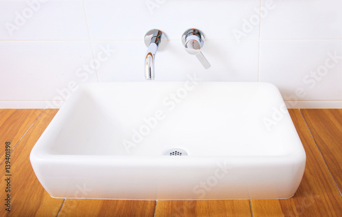White porcelain washbasin and chrome-plated faucets.