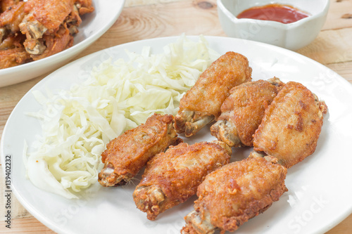 Chicken wings in plate with and cabbage alley. © nayladen