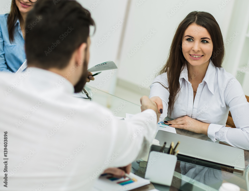 handshake between the Manager and the client after the signing of the financial agreement in the workplace in the office handshake between the Manager and the client after the signing of the financial agreement in the workplace in the office