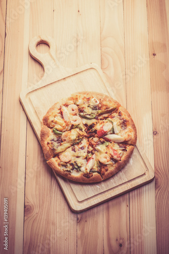 Seafood Italian Pizza slice on wood background