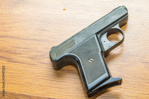 black handgun on wooden background