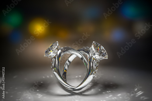 3d rendering of diamond rings with copy space closeup in dark environment with bokeh background.