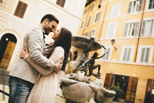 Young couple in love hugging near the fountains in Rome