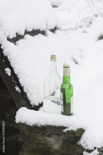 Bottles with alcohol on snow.