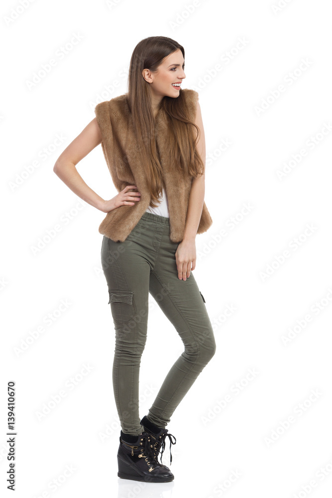 Woman In Fur Waistcoat And Khaki Pants Side View Woman In Fur Waistcoat And Khaki Pants Side View