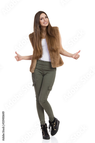 Woman In Khaki Pants And Fur Vest Showing Thumbs Up