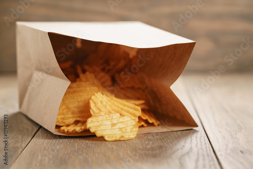 rippled potato chips with paprika in paper bag  shallow focus