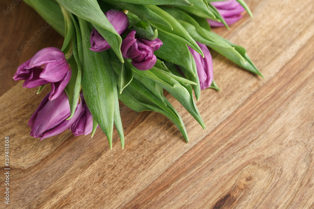 bouquet of purple tulips on wood table with copy space, shallow focus bouquet of purple tulips on wood table with copy space, shallow focus