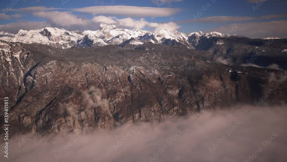 Triglav mountain peak under snow over the lake Bohinj valley in fog Triglav mountain peak under snow over the lake Bohinj valley in fog