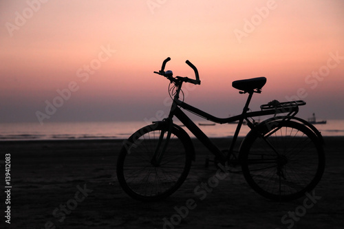 Silhouette of a bicycle on the beach