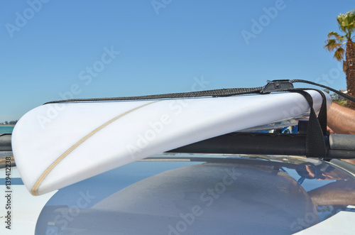Tying a Surfboard onto a roof of a car