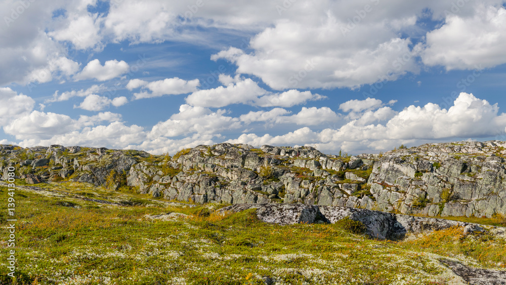 Hills,tundra,rocks and sky with white clouds.