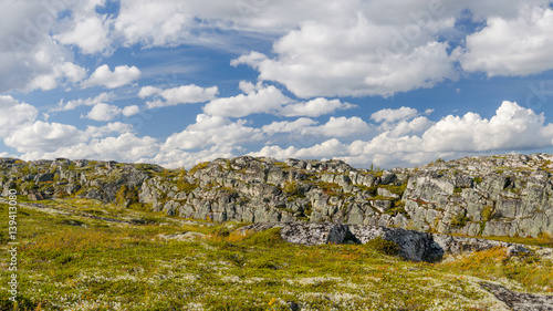 Hills,tundra,rocks and sky with white clouds.