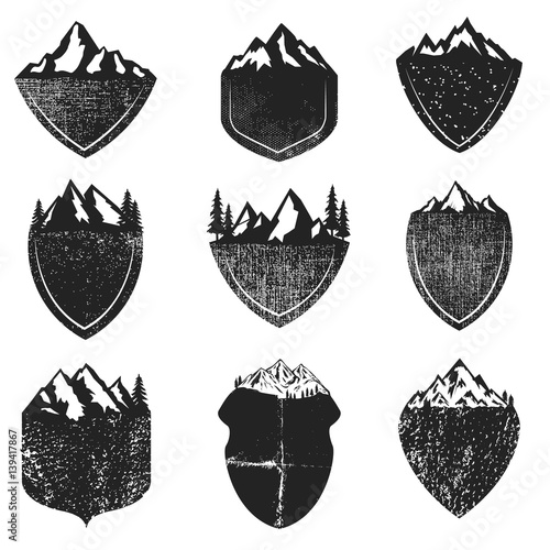 Set of Grunge badges with mountains isolated on white background. Design elements for logo, label, emblem, sign. Vector illustration.