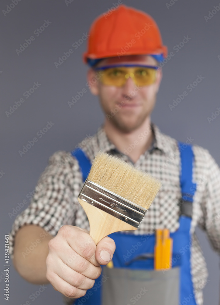 Paint brush and blurred figure of Happy modern young worker Paint brush and blurred figure of Happy modern young worker