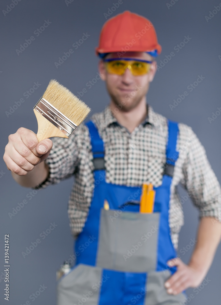 Paint brush and blurred figure of Happy modern young worker Paint brush and blurred figure of Happy modern young worker