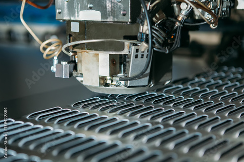 close up of cnc punching press machine with metal plate