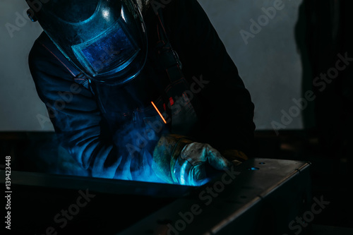 sparks while welder uses torch to welding © Olga