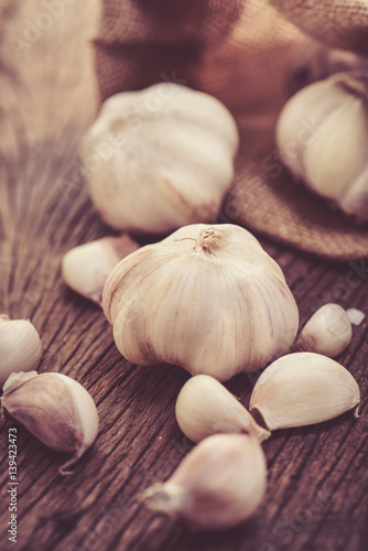 garlic with sack on wood background