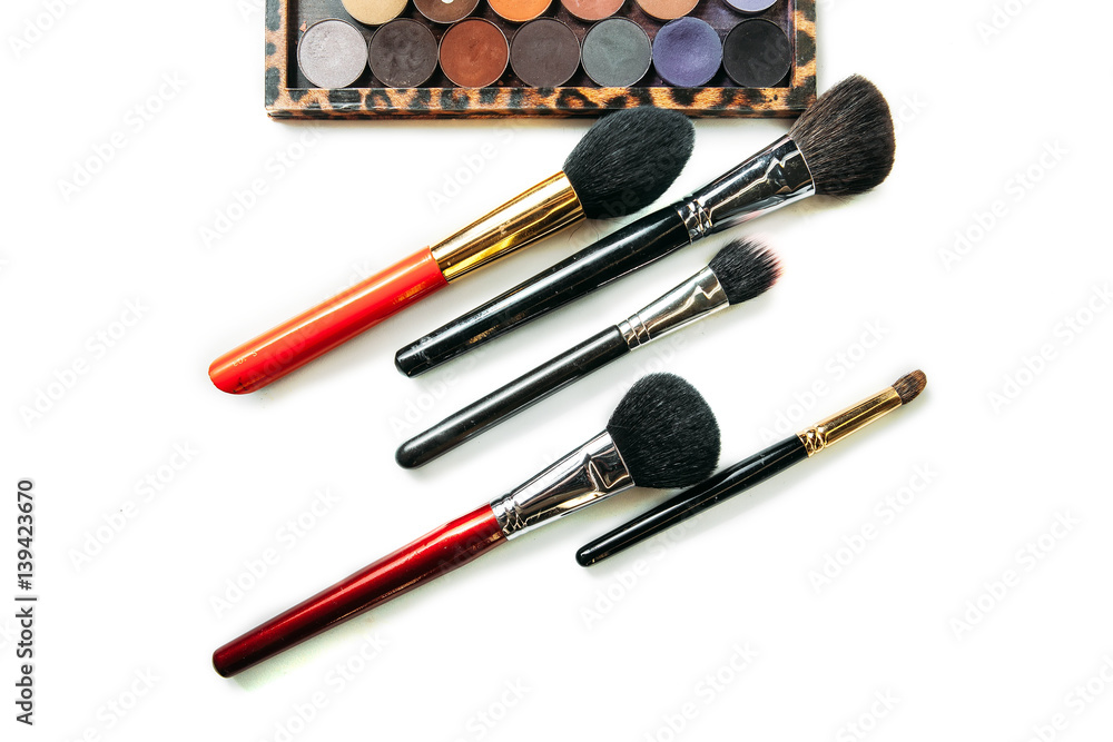Makeup collection brushes and shadows isolated white background Makeup collection brushes and shadows isolated white background