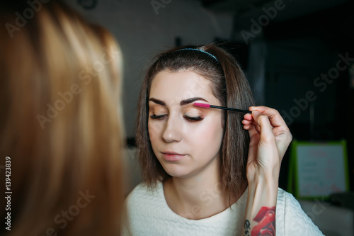 Beautiful model having powder applied by makeup artist