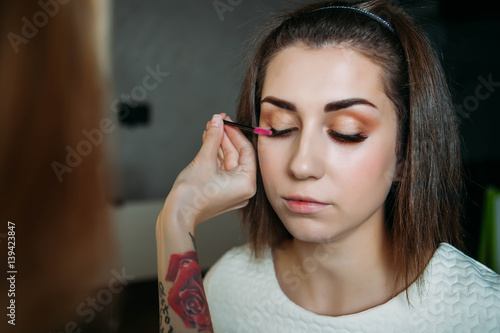 Beautiful model having powder applied by makeup artist