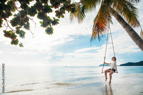 Happy woman on a swing tropical island