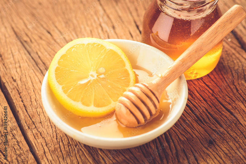 Lemon slice with honey on wood table Lemon slice with honey on wood table