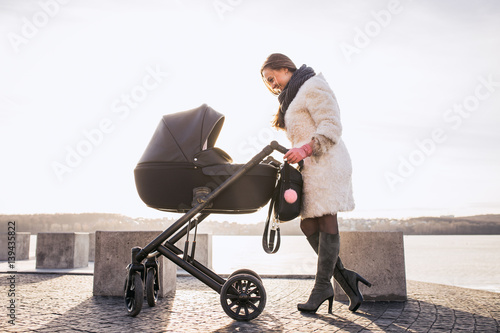 young mother walking with baby, good weather for walking, healthy lifestyle