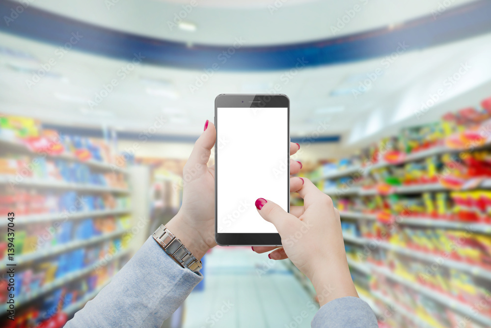 Women in grocery store buying supplies, holding modern phone in hands. Shopping online concept mmockup Women in grocery store buying supplies, holding modern phone in hands. Shopping online concept mmockup