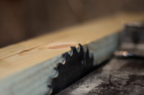 Board on a table of circular saw. Selective focus
