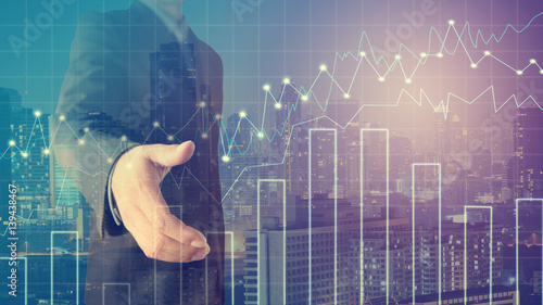 Foto Businessman offering for handshake with cityscape and financial graph on blurred