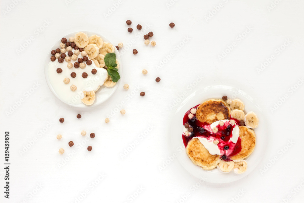 Dessert with yogurt, muesli, banana, pancake and berries on white background. Flat lay Dessert with yogurt, muesli, banana, pancake and berries on white background. Flat lay