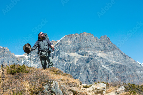 Hiker in dark grey Jacket and Pants in the Mountains