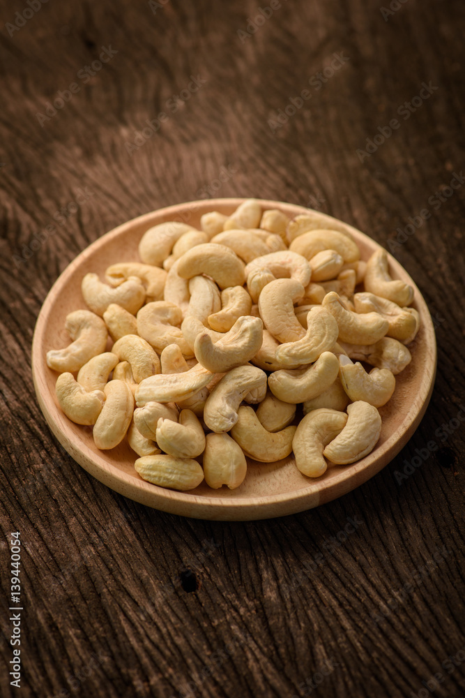 close up of cashew nut in wood dish close up of cashew nut in wood dish