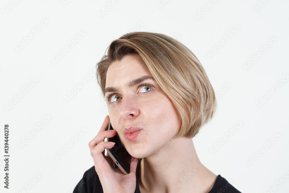 Businesswoman talking on the phone very emotional. She smile, anger, aggression, misunderstood, outrage. On a white background. Happy smiling successful businesswoman with cell phone, isolated on Businesswoman talking on the phone very emotional. She smile, anger, aggression, misunderstood, outrage. On a white background. Happy smiling successful businesswoman with cell phone, isolated on