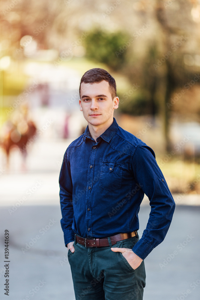 One young business man standing in park background