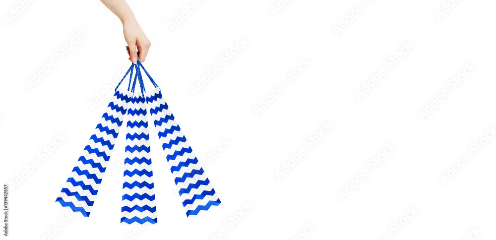 Obraz premium Woman hand holding blue shopping bags on white background, clipping path
