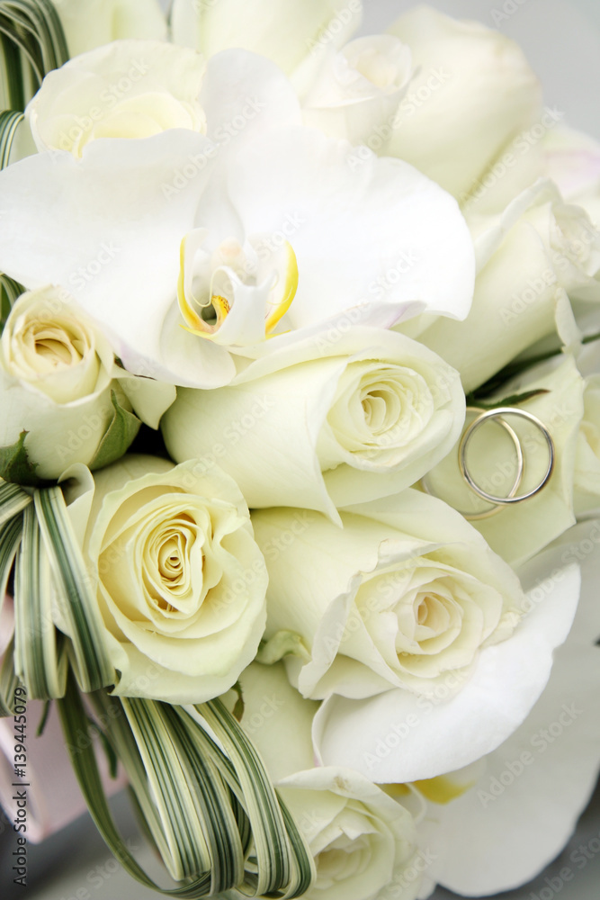 Obraz premium background of beautiful wedding bouquet of roses and orchids and two gold and platinum wedding rings