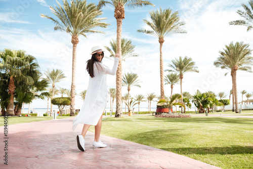 Happy cute young woman walking and dancing on summer resort