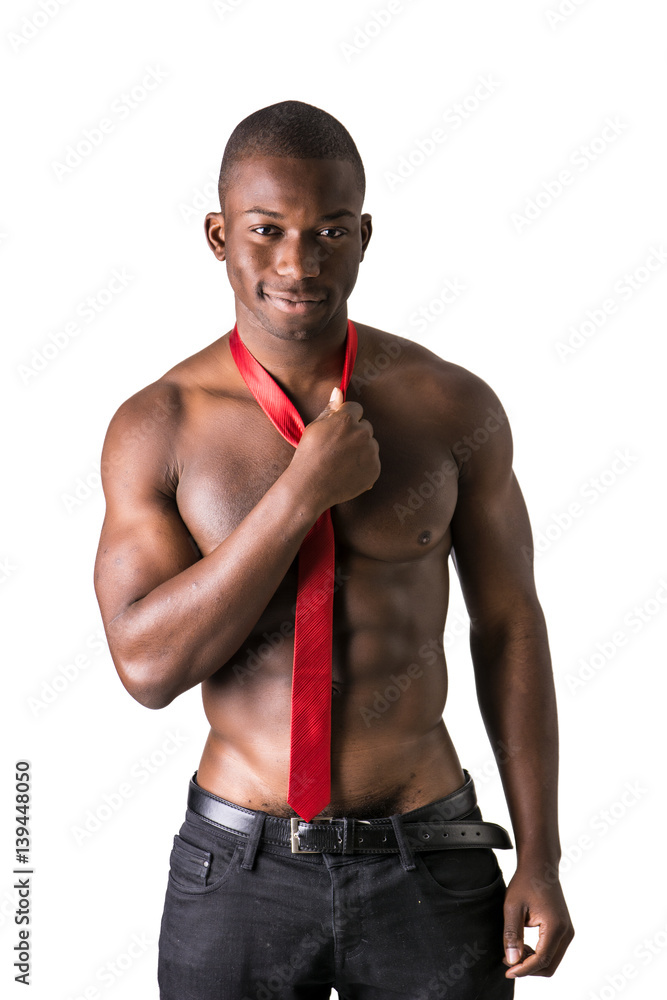Attractive black young muscle man naked, wearing only pants and red necktie, isolated on white