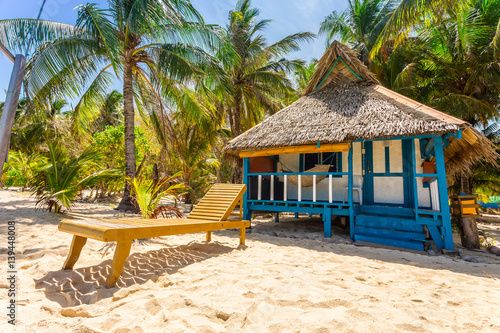 Beach chairs, clear water and beautiful view on tropical island,