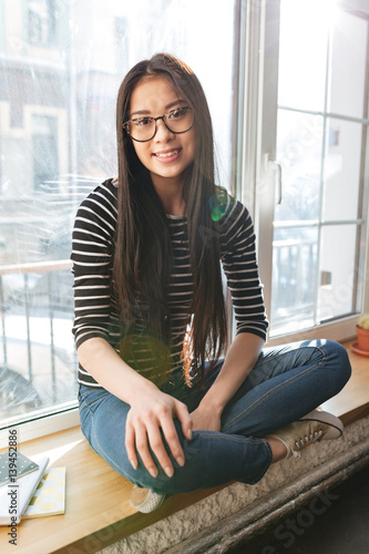 Vertical image of Asian woman on windowsill Free Download Vertical image of Asian woman on windowsill - GFXLoad