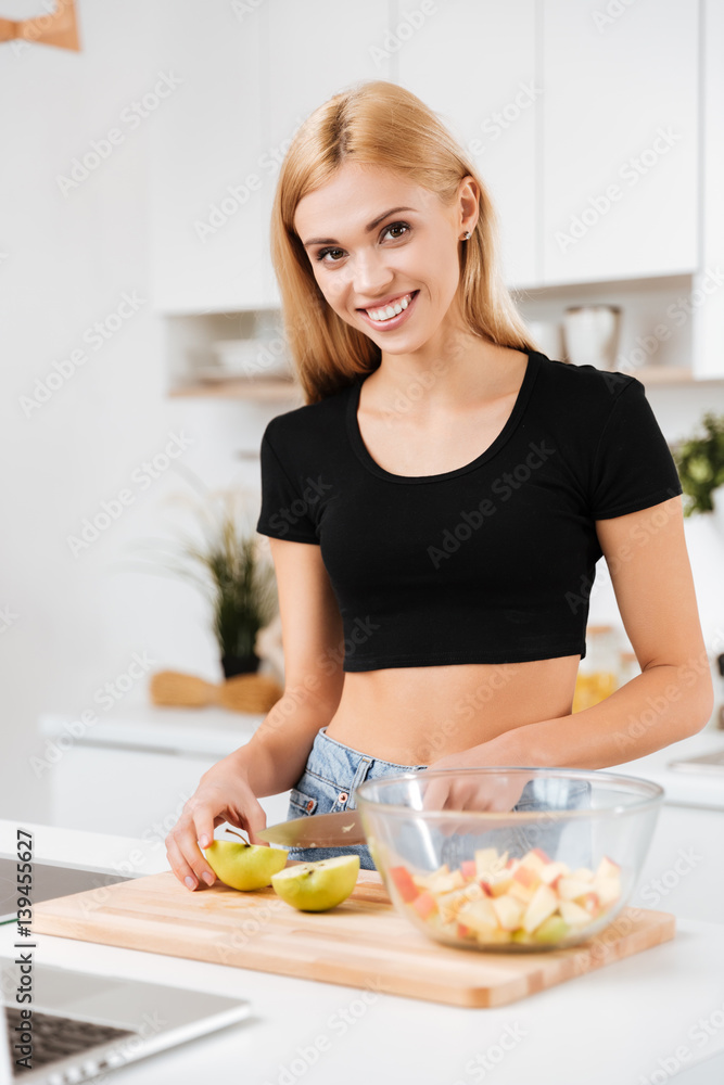 Vertical image of Smiling woman cutting apples Vertical image of Smiling woman cutting apples