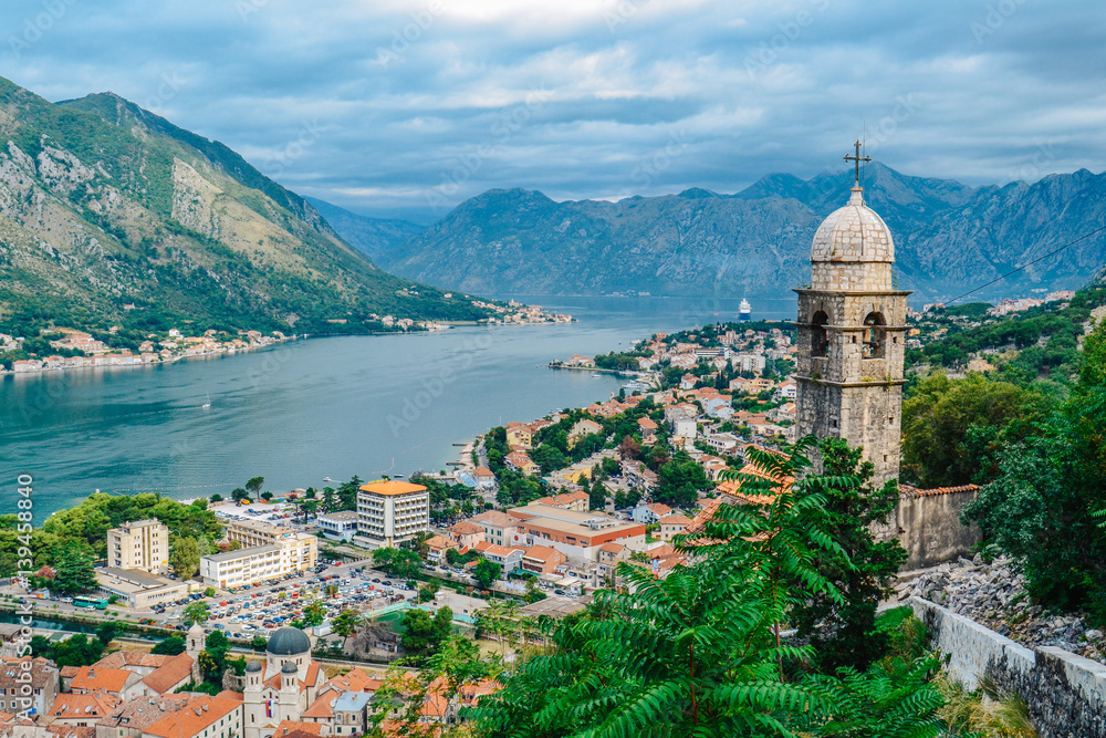 Panoramic view of town and mountains with church in foreground in Kotor, Montenegro