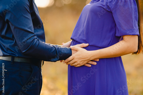 Pregnancy. A man holds his hands on his belly in a pregnant girl's child. Concept love, conception and the birth of a child.