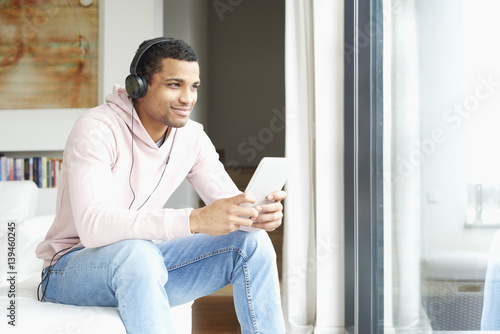Enjoy music. Young African American man listening music on digital tablet Free Download Enjoy music. Young African American man listening music on digital tablet - GFXLoad